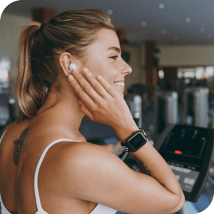 Woman listening to workout music on digital fitness connected device with earbud
