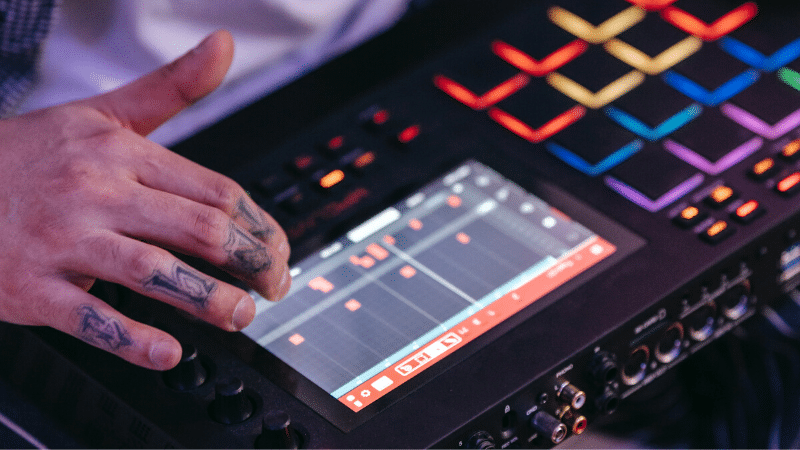 Bodega Sync’s Guide to Leased Beats & Royalty-Free Samples person producing sampled music on electronic deck