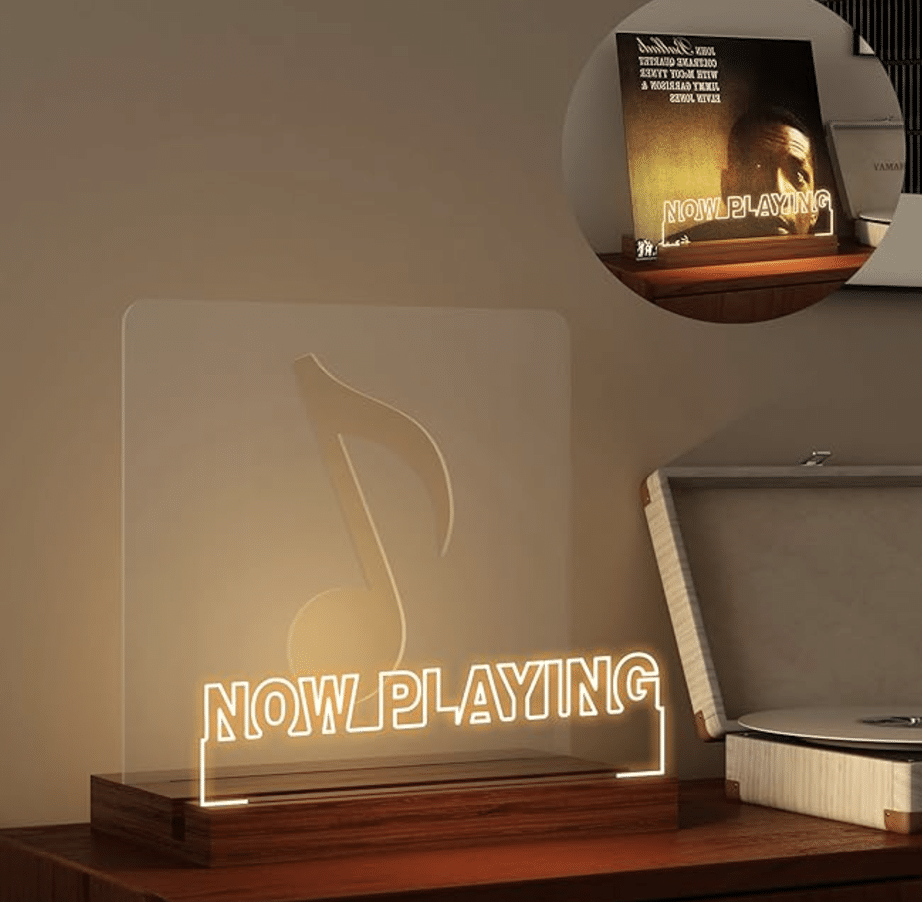 gift ideas of musicians - An illuminated "Now Playing" sign with a clef symbol sits on a shelf next to a vinyl record player, perfect as gift ideas for musicians. A smaller inset shows the sign alongside a record album.
