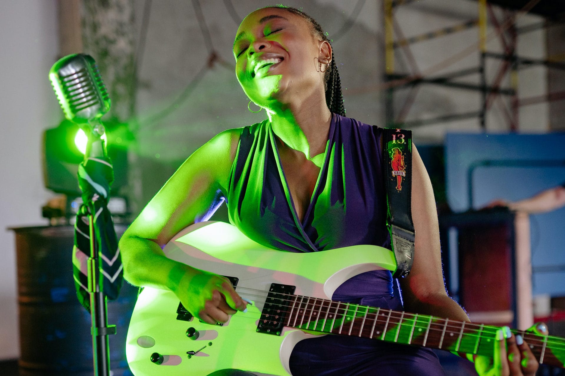 woman playing guitar and singing on stage