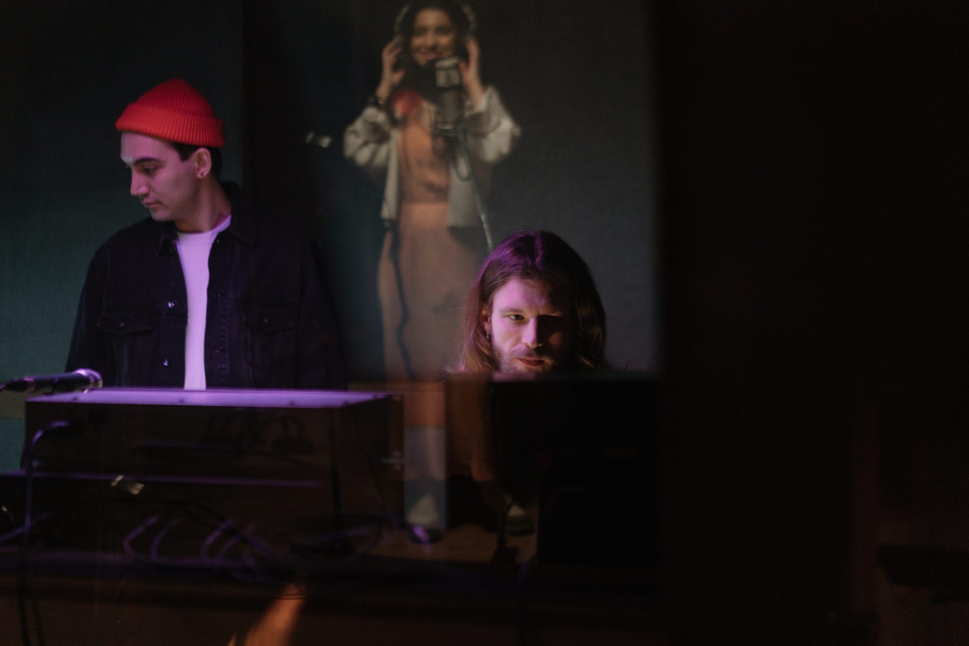 three artists collaborating in a music studio