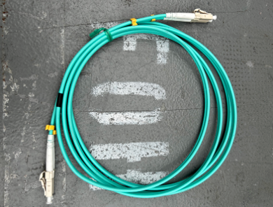 A screen grab of a green optical MADI cable is pictured on a grey background