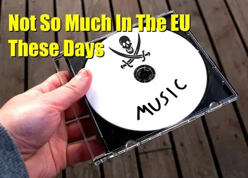 CD with skull and crossbones graphic labeled "MUSIC," held over wooden surface.