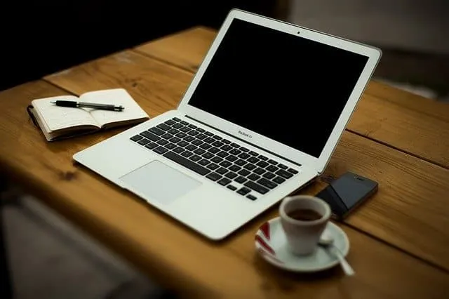 Laptop, notebook, pen, coffee cup, wooden desk, workspace, technology, work from home, digital workspace, modern office setup