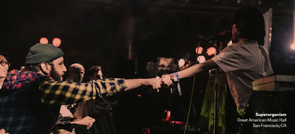 Fan sharing a concert moment at a live music event, audience interaction, music performance, San Francisco, CA, music venue,