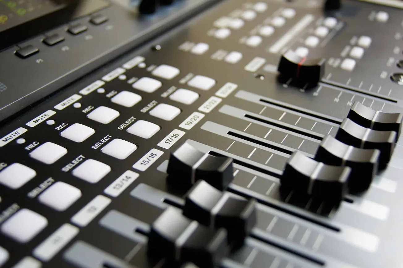 Studio audio mixing console with faders and controls for professional music production and sound engineering.