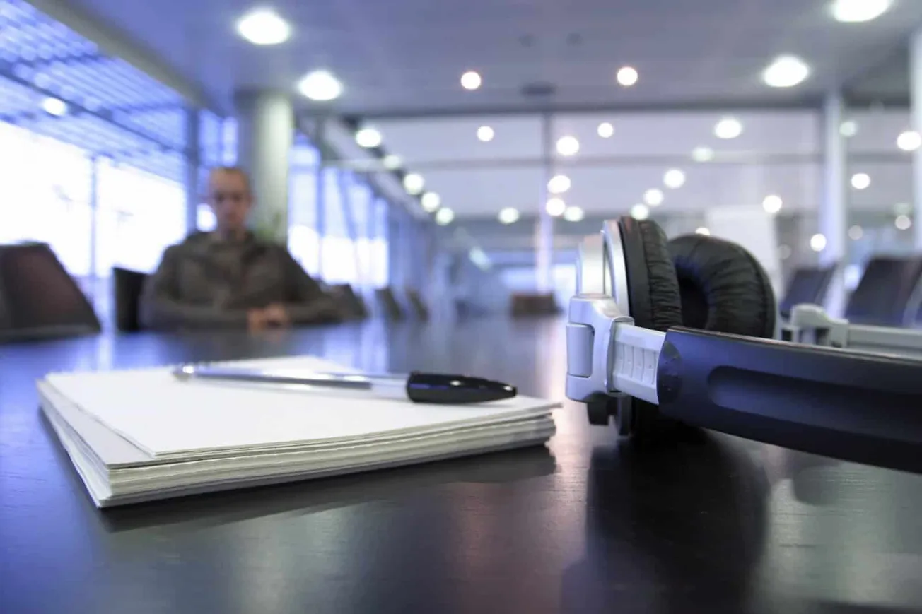SKU search meeting room with headphones, documents, and conference table, modern office environment, blurred background, prof