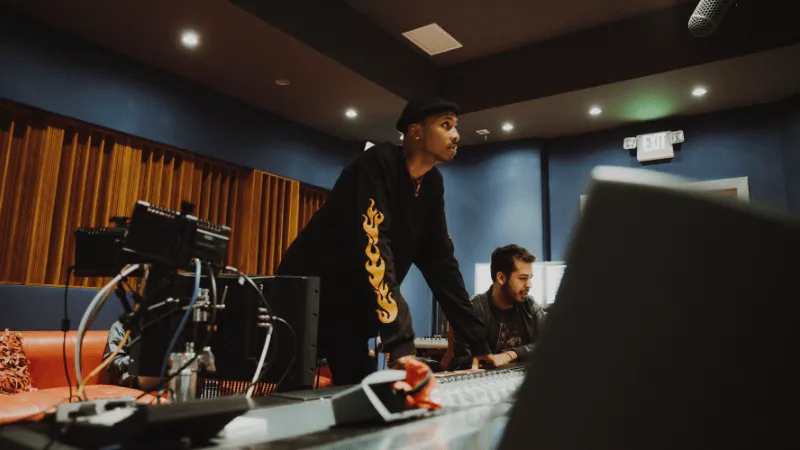 Music producers working in a professional recording studio, focusing on mixing and sound engineering for upcoming music proje