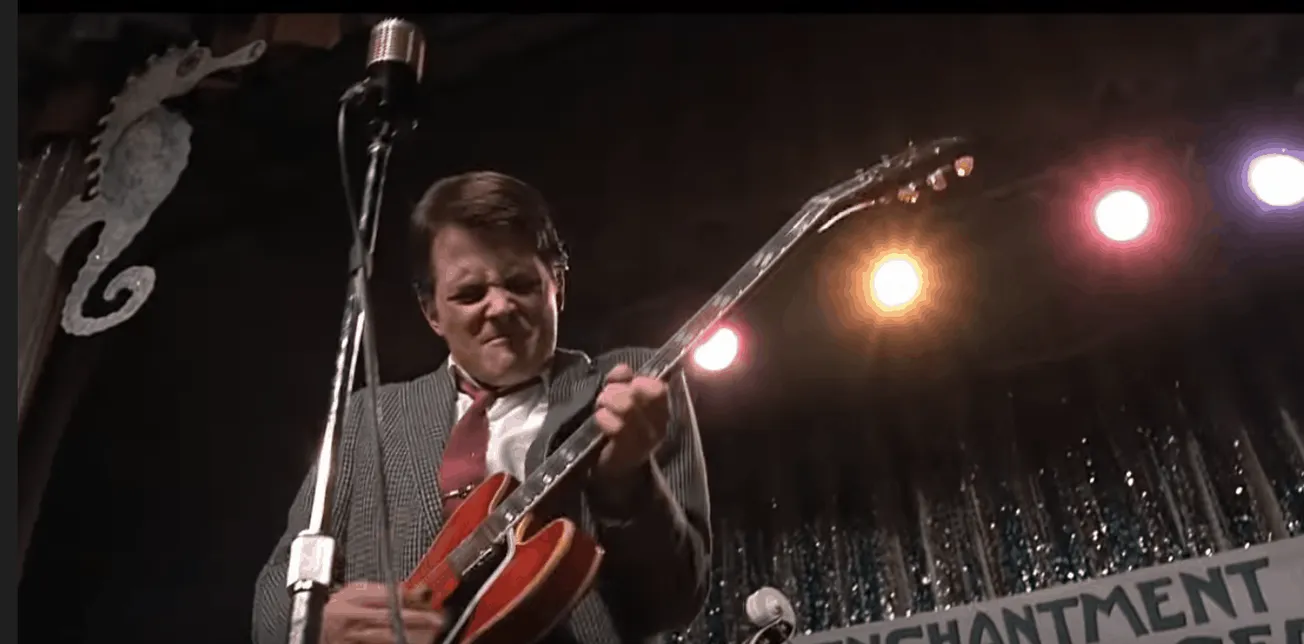 Guitarist playing passionately on stage during a live concert with colorful stage lights; vibrant rock performance scene.