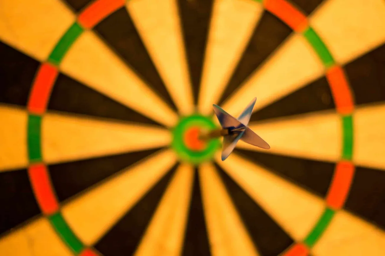 Aiming Dart on Target Board for Precision and Goal Setting, Close-up of Dart Hitting Bullseye in a dartboard, representing fo