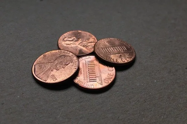 Pennies on dark surface, close-up photo of U.S. one-cent coins, copper pennies with Lincoln faces, used in financial or monet