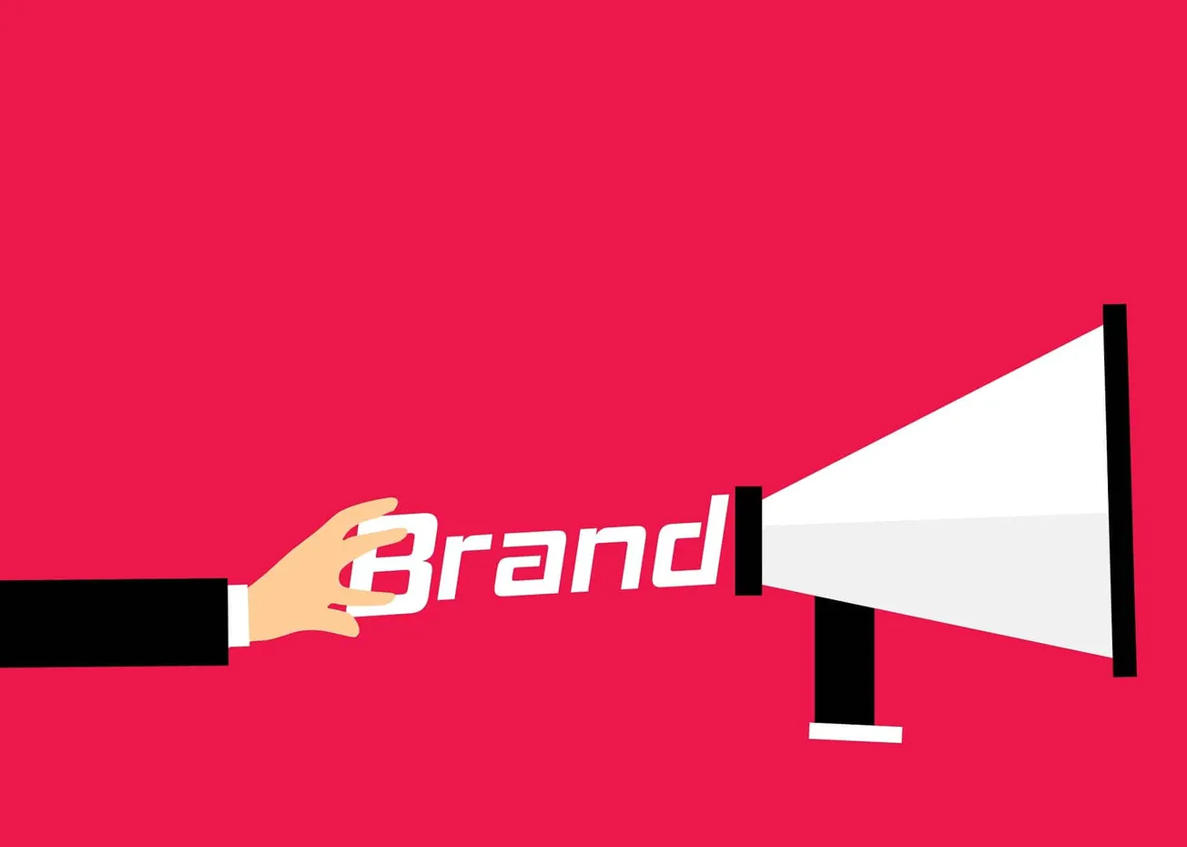 Brand promotion concept with hand holding the word "Brand" projecting through a megaphone or speaker on a red background, sym