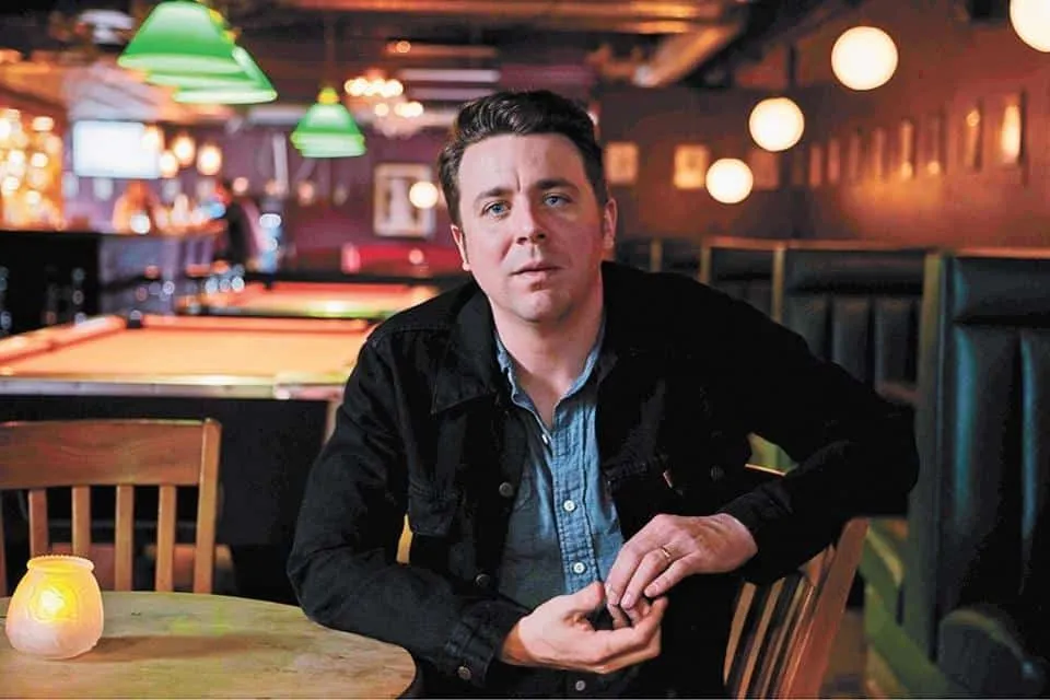 People enjoying a night out at a cozy bar with billiards, ambient lighting, and casual atmosphere.