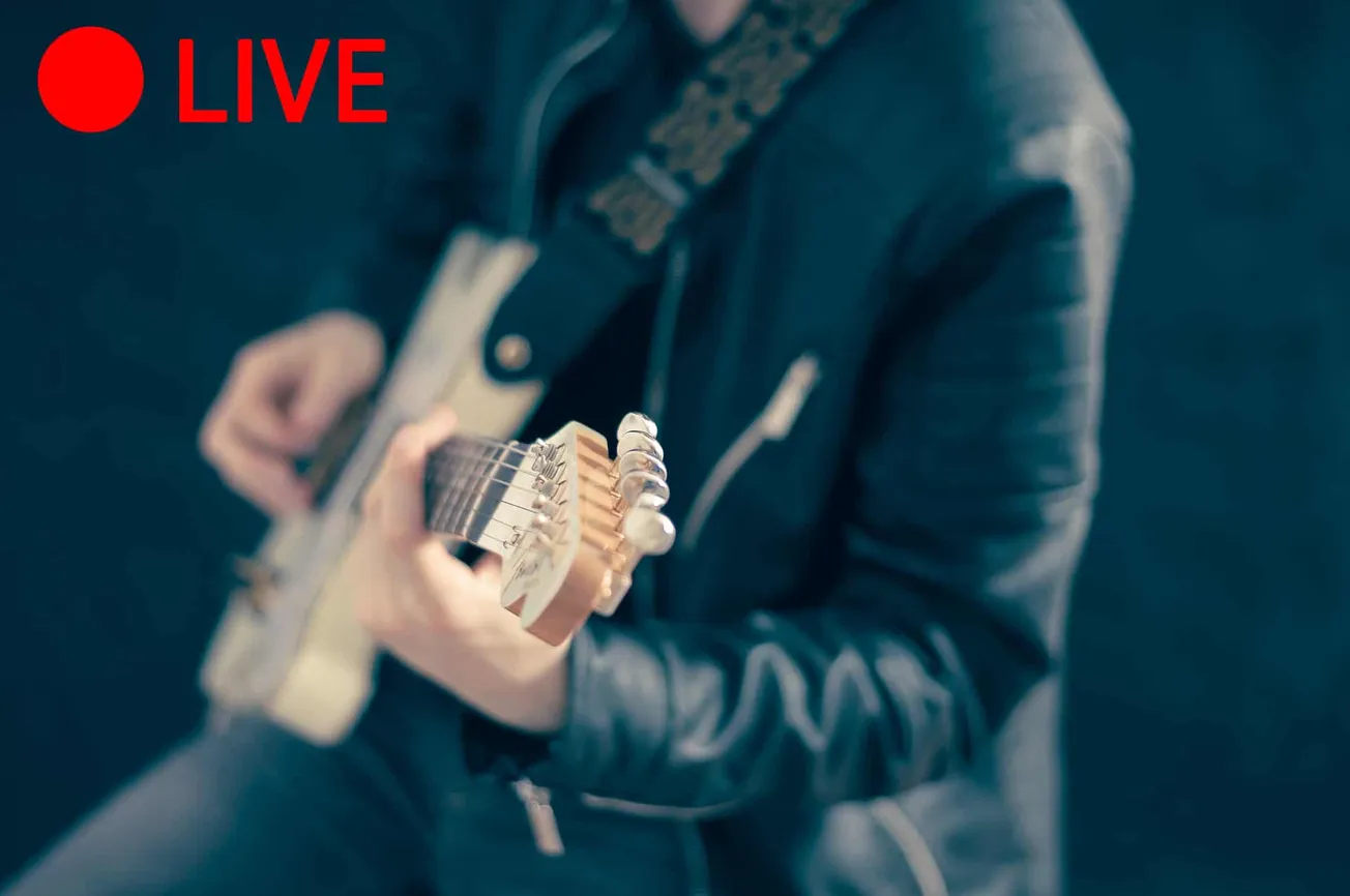Electric guitar player wearing a black leather jacket, focusing on tuning the guitar, with a blurred background. Ideal for mu