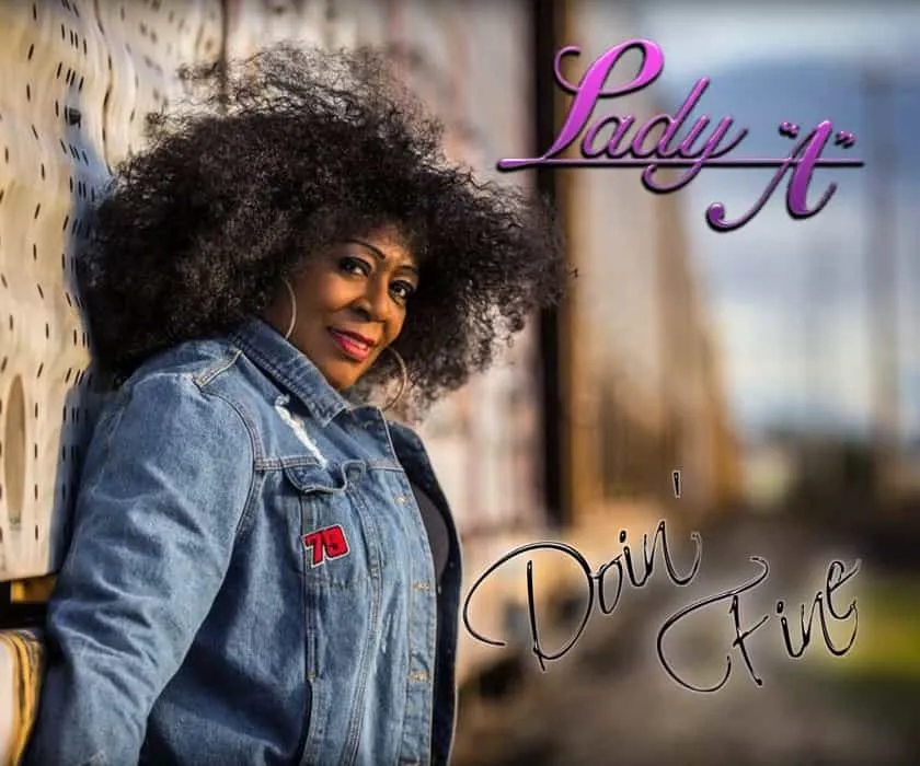 Lady 'A' posing outdoors in casual denim jacket, with a natural hairstyle, evoking confidence and individuality, promoting em