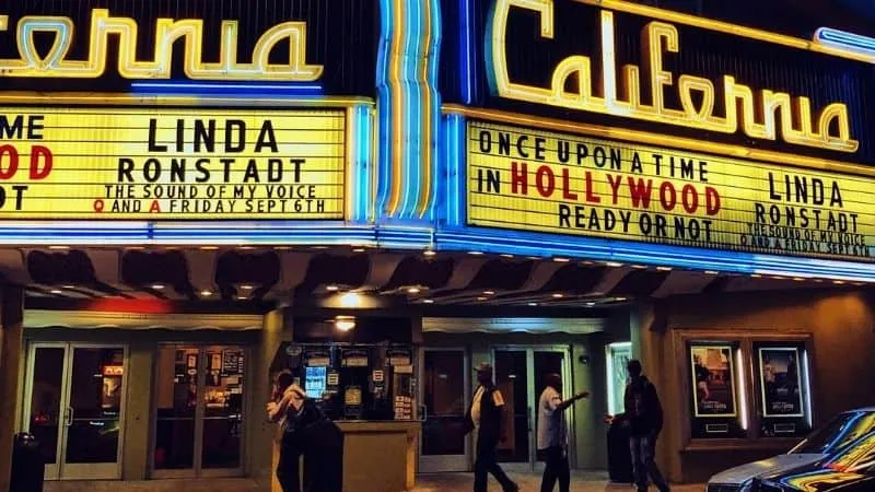 Hypebot, music industry news and tech insights, on a vibrant theater marquee with people entering Hollywood event.