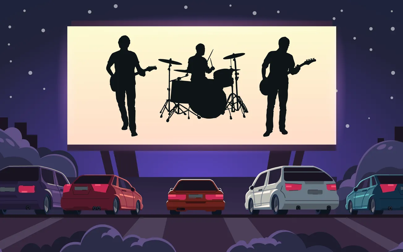 Silhouettes of a band playing on a large outdoor movie screen at night with cars parked in front, creating a lively outdoor c