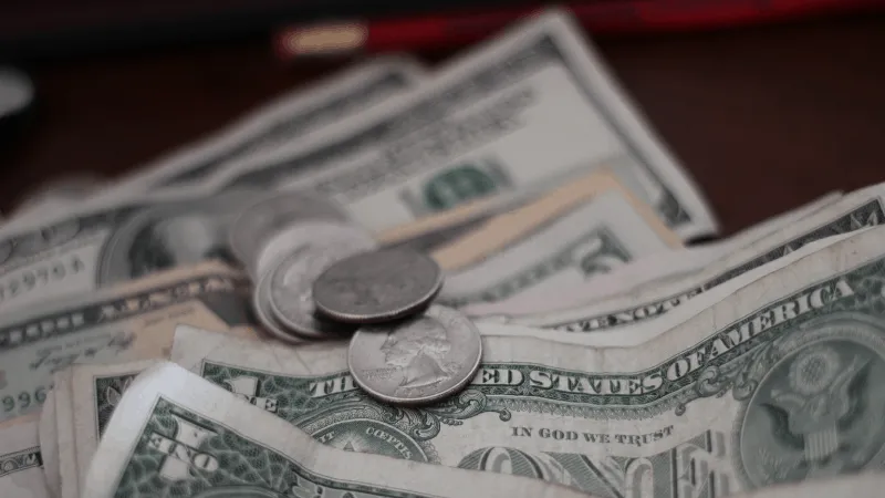 Stacks of US dollar bills and coins, representing earnings, revenue, or financial growth in the music industry and digital me