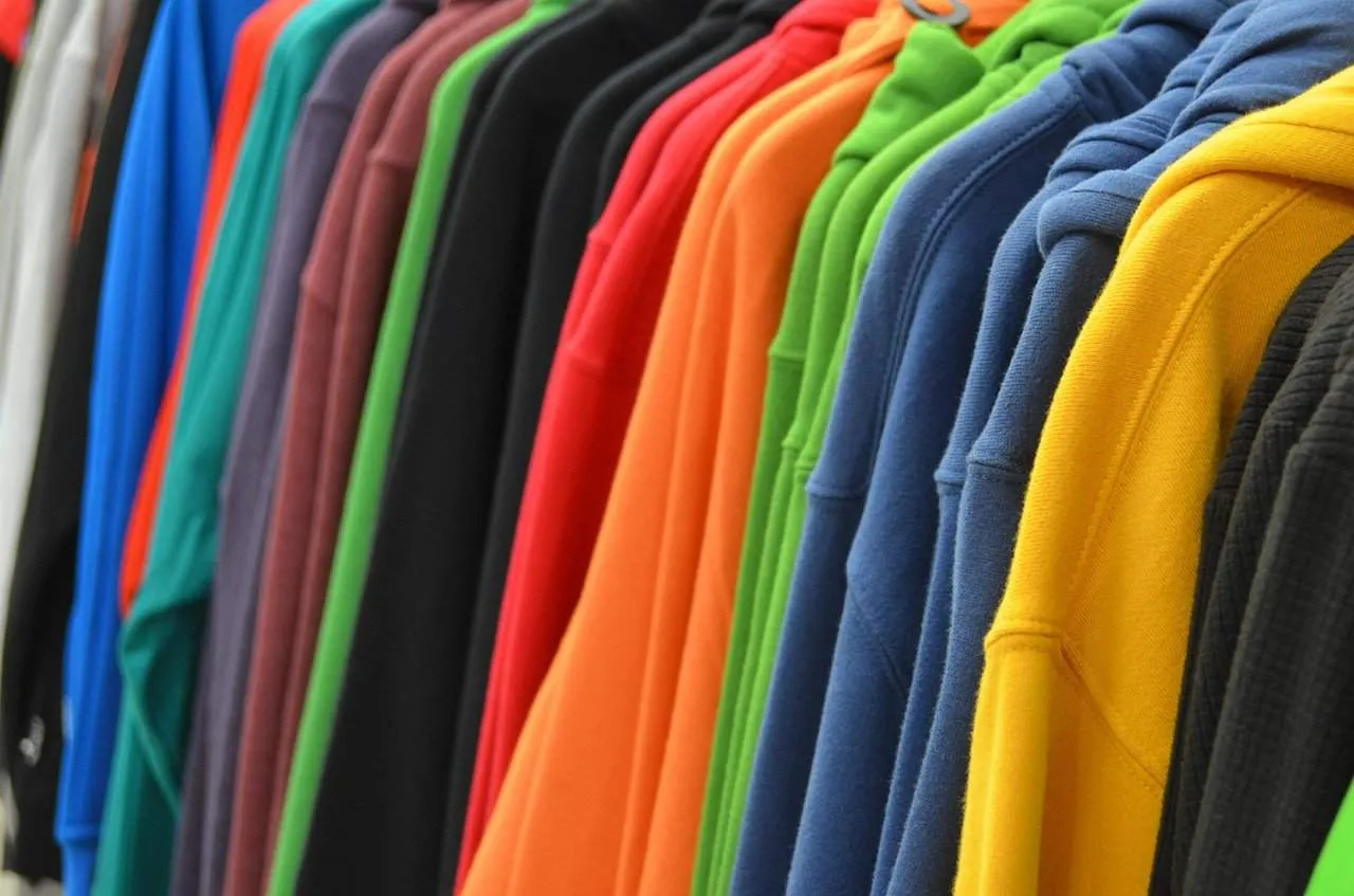 Colorful hoodies displayed on a clothing rack, casual hoodie apparel collection, vibrant sweatshirt varieties, fashion hoodie