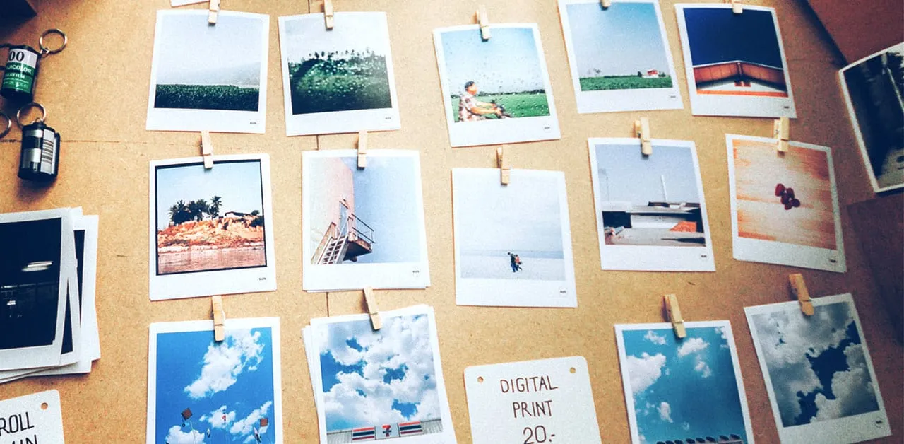 Polaroid photos hanging on a string with clothespins, showcasing outdoor landscapes and sky scenes, with film canisters and c