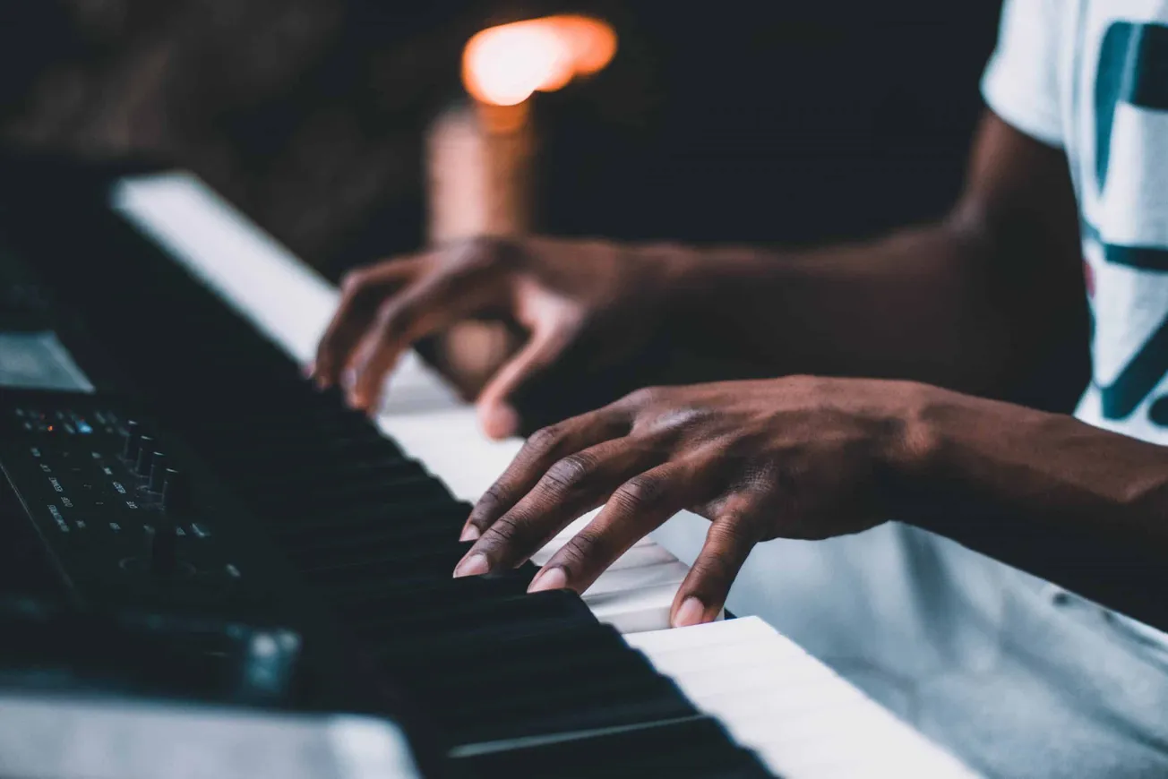 Hands playing digital piano, close-up shot, musician practicing piano, black keys, music composition, dark background, music