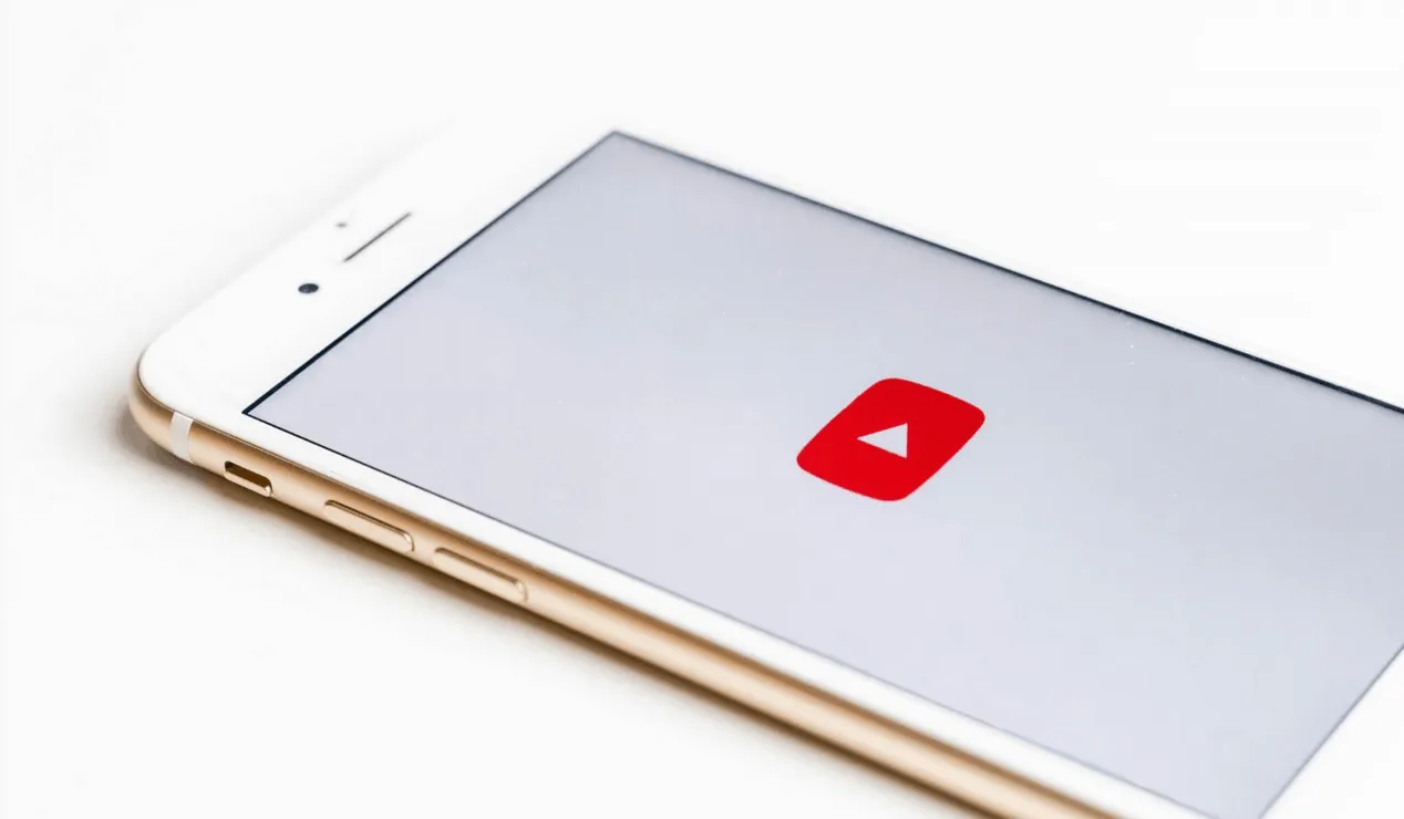 Mobile phone with YouTube app open, showcasing video content, representing digital media, online streaming, and content creat