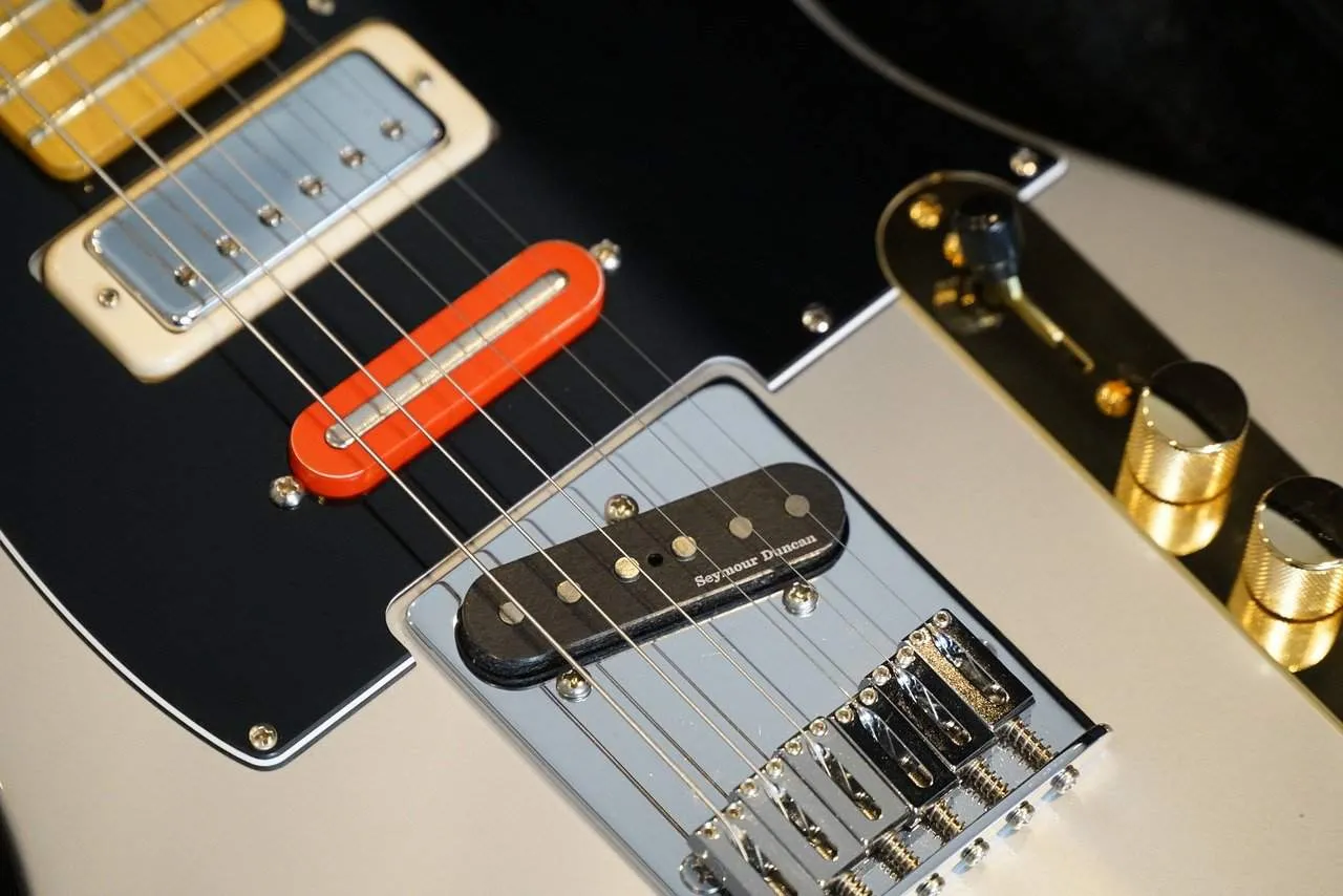 Electric guitar close-up with pickups and control knobs, focusing on the hardware details and craftsmanship for music and ins