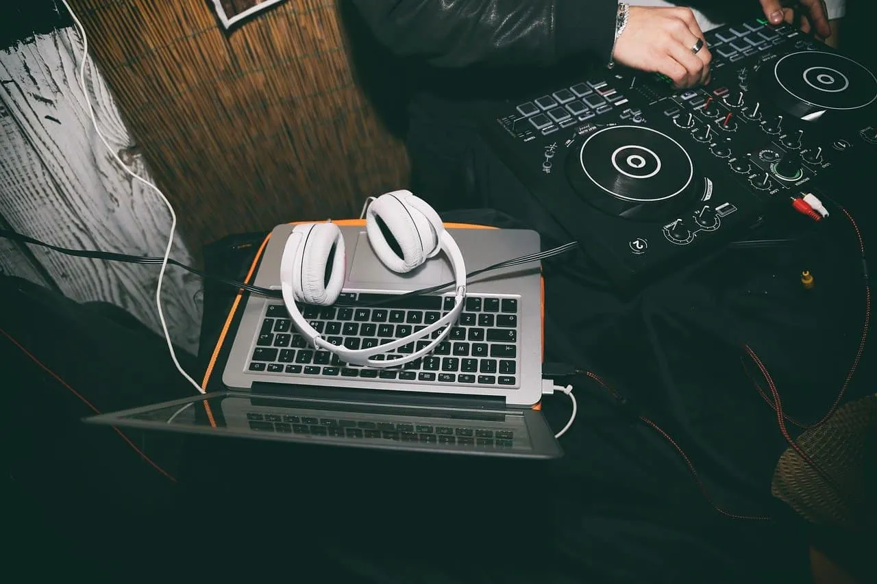 DJ controller and headphones setup for music production or DJing, showcasing electronic music equipment on a laptop and mixer