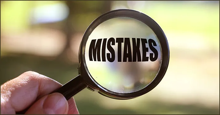Mistakes written on a magnifying glass to symbolize error detection and analysis in business or creative projects.