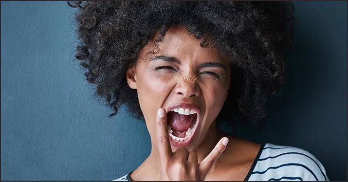 Expressive young woman shouting with frustration or excitement, showcasing strong emotion and energetic attitude, against sol