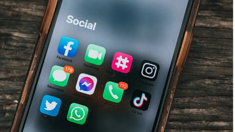 Social media icons on a smartphone screen, including Facebook, Messenger, TikTok, WhatsApp, Twitter, and Instagram, highlight