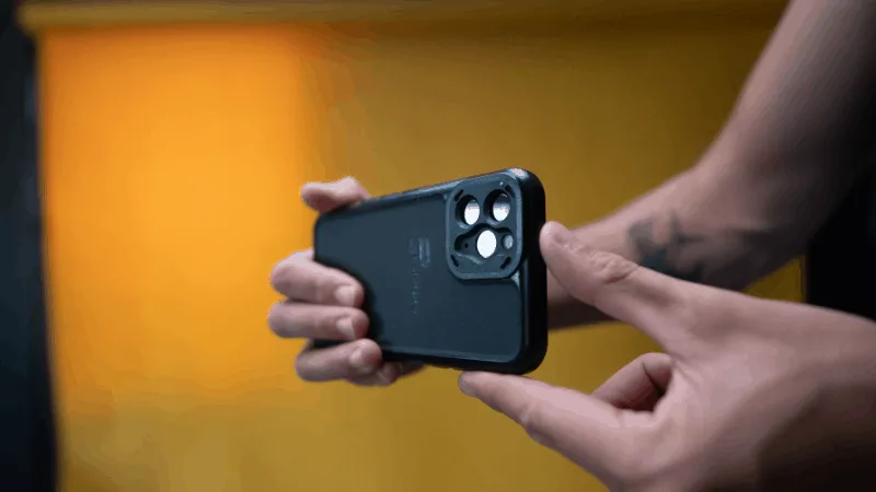 A person holding a smartphone with a focus on the camera lenses, ready to capture photos or videos.