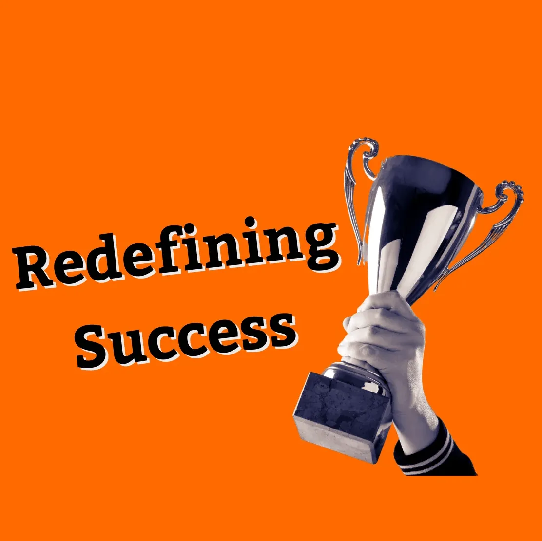 Trophy being held by a person's hand with the text "Redefining Success" on a solid orange background, symbolizing achievement