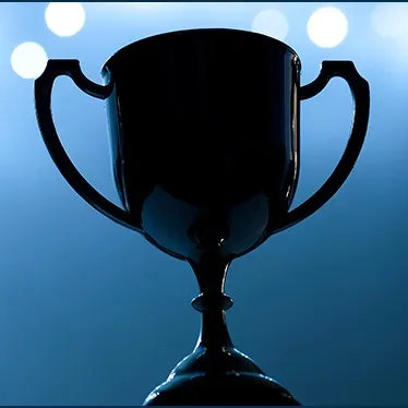 Shiny black trophy cup with handles, illuminated against a blue background with bokeh lights, symbolizing achievement and suc