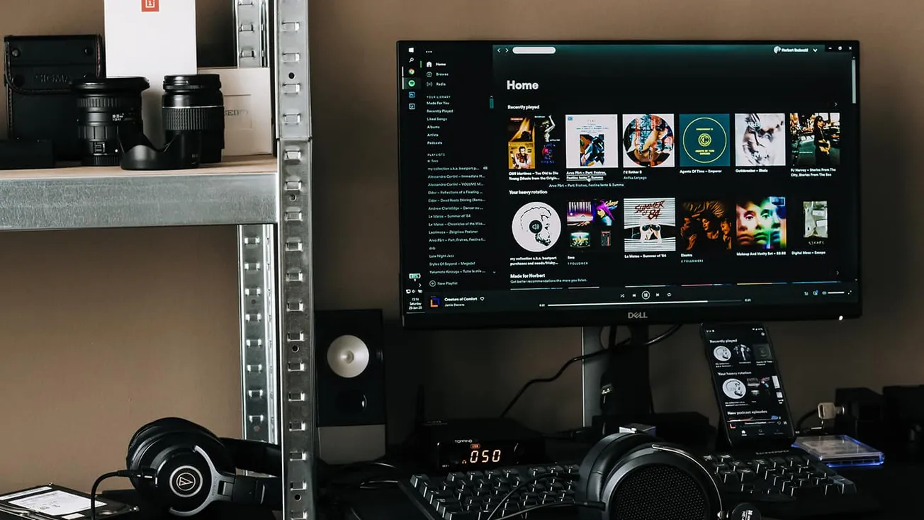 Music production workstation with DJ headphones, digital audio equipment, and monitors, showcasing modern music streaming and