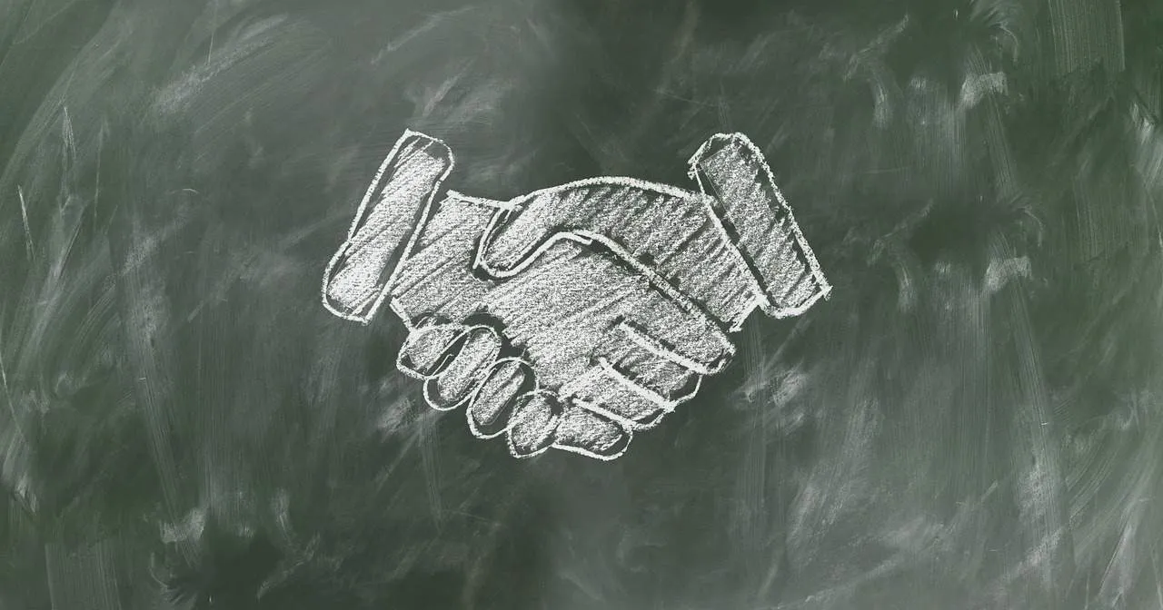 Handshake agreement symbol chalk drawing on blackboard, business partnership or collaboration concept, teamwork, trust, negot