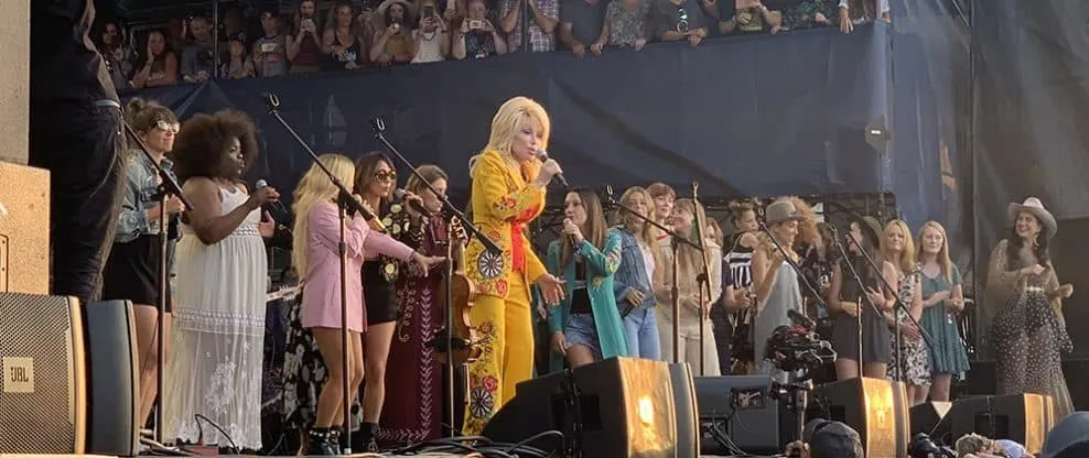Children and women singers perform on stage at a concert, emphasizing live music events and audience engagement.