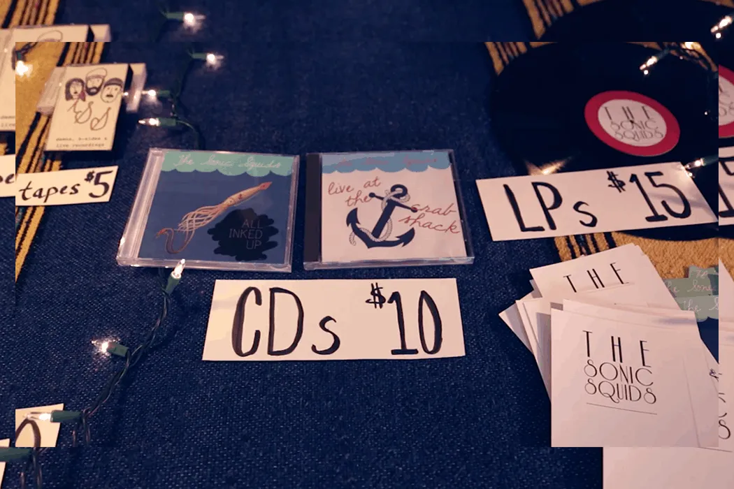 Handmade indie music CD and vinyl records for sale at an underground music event, showcasing album artwork and pricing, with