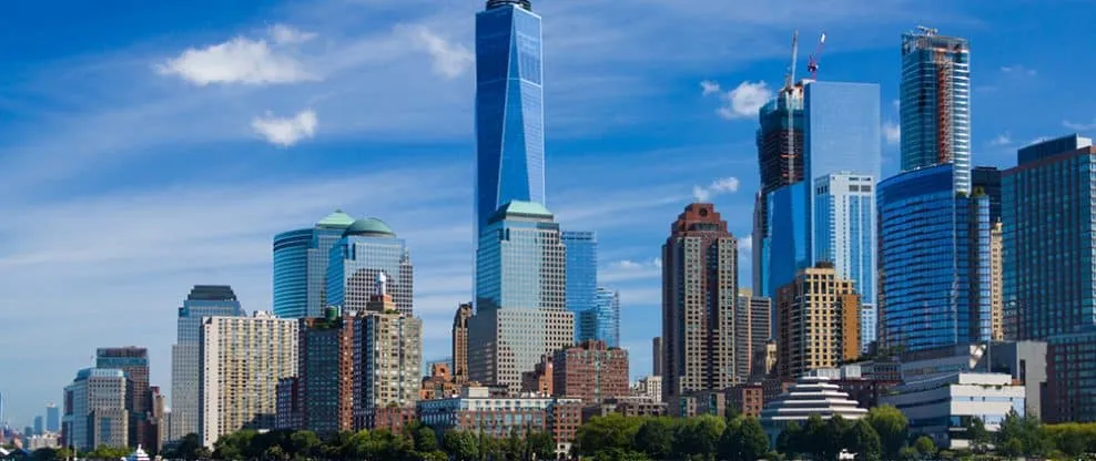 Skyscraper cityscape of downtown New York City with modern glass buildings and blue sky, capturing the vibrant urban environm