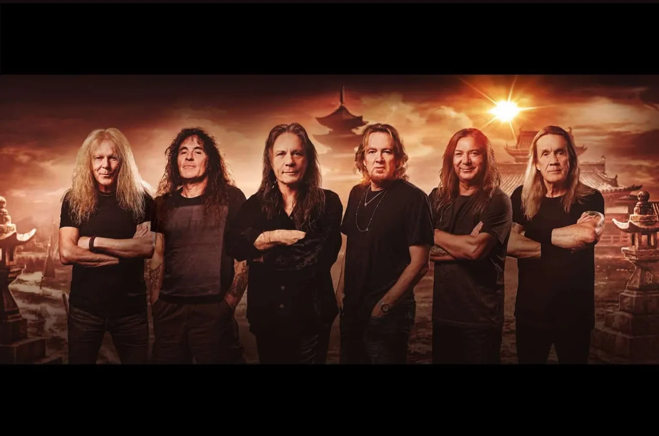 Legendary rock band members standing against a dramatic Asian-inspired backdrop with sunset lighting, showcasing classic rock