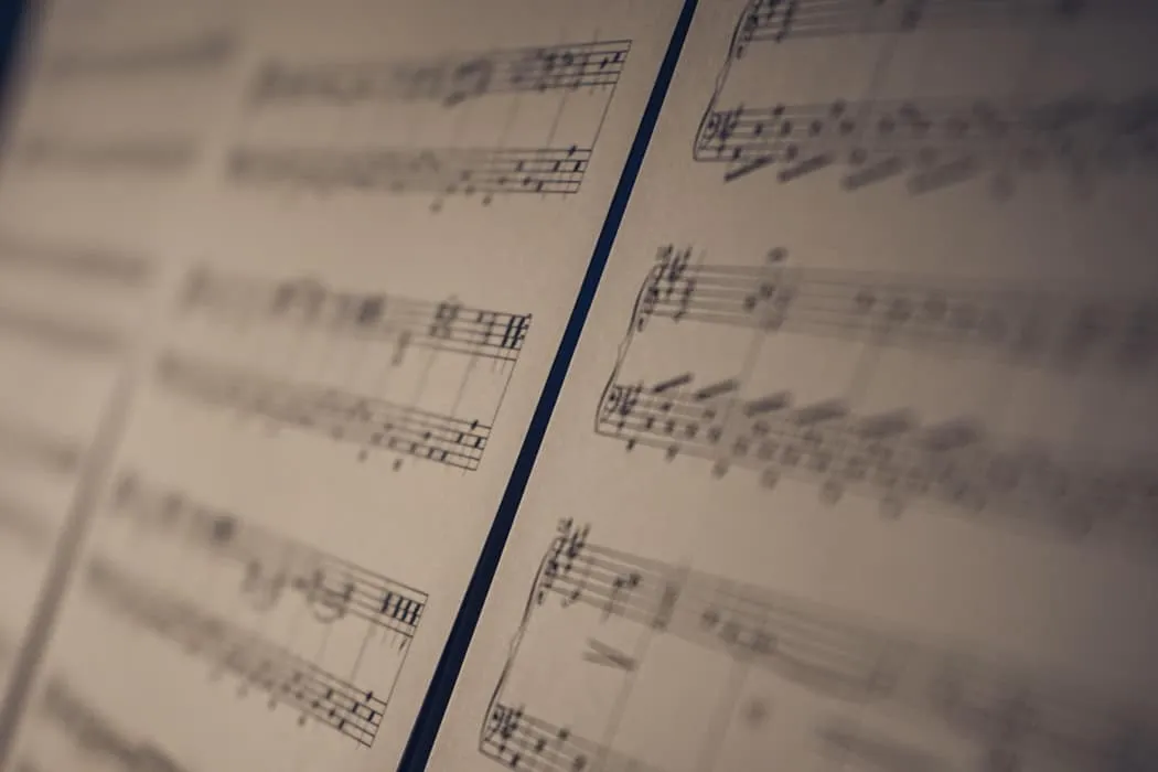 Vintage sheet music with musical notes and notation, close-up view, for music industry articles, music trends, and digital mu