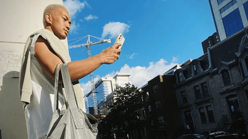 Hypebot urban young man taking selfie with cityscape background, construction crane and high-rise buildings, trending music i