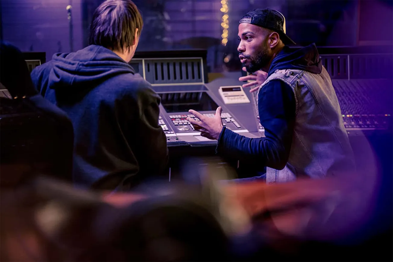 Collaborative music production in a modern recording studio featuring sound engineers and music producers.