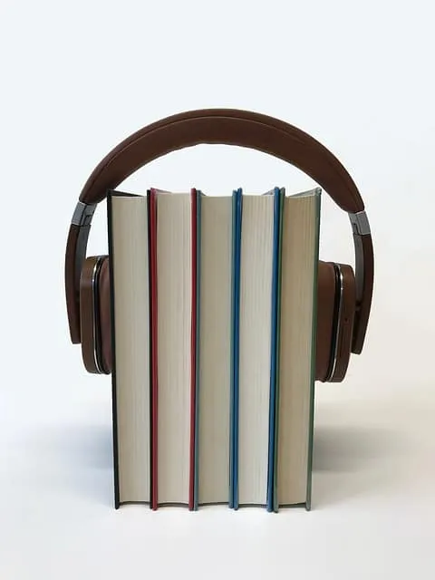 Headphones placed in front of a row of books, symbolizing audio books, music, or learning.