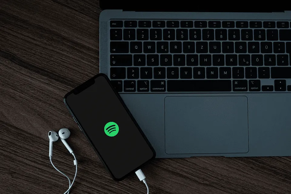 Wireless Spotify streaming on laptop and smartphone for music enthusiasts and digital marketing professionals.