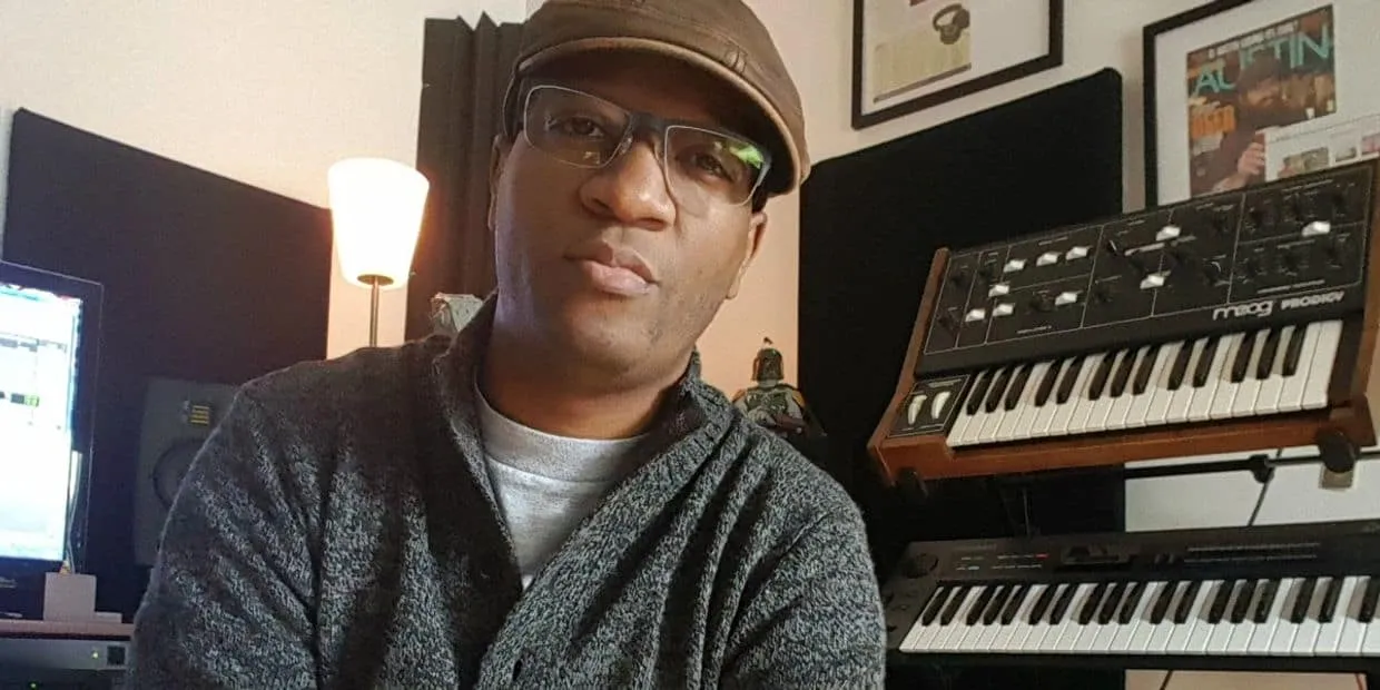 Music producer working in a home studio with synthesizers, keyboard, and mixing equipment for innovative music creation and p
