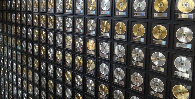 Gold record plaques wall for music achievements and industry recognition.
