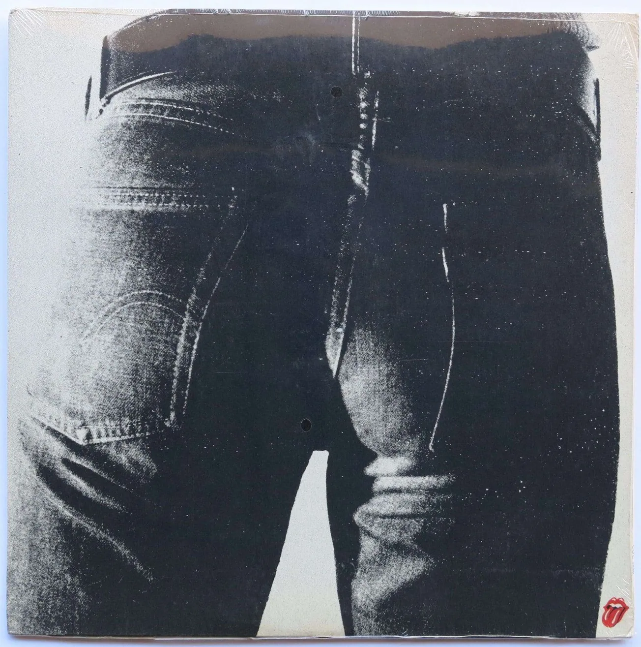 Black and white close-up photo of a person's backside wearing distressed denim jeans, showing the back pockets and waistband,