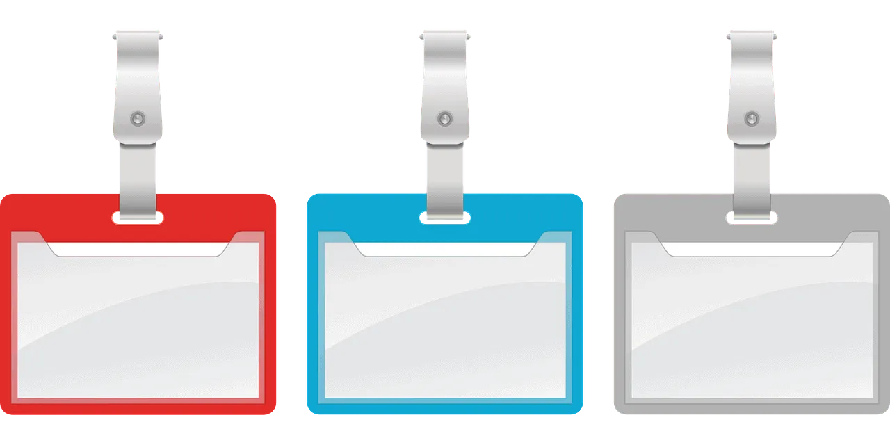 Red, blue, gray conference badge holders on pink background, LED color indicators, event credential holders, ID badge clips,