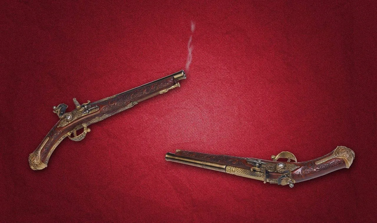 Intricate antique flintlock pistols with ornate designs and wooden engravings displayed on a red textured surface.